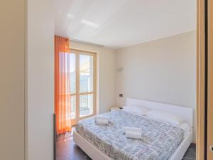 a white bedroom with a bed and a window at EnjoyIseoLake - Modigliani in Parzanica