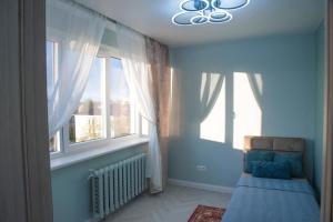 a bedroom with a bed in a room with windows at Fountain View 2 bedroom Apartment in Naujoji Akmenė