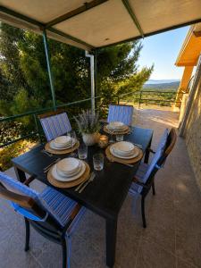 a black table with plates and chairs on a patio at Villa Aura in Milna