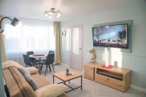a living room with a couch and a tv on the wall at Fountain View 2 bedroom Apartment in Naujoji Akmenė