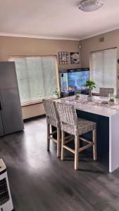 a kitchen with a table and chairs and a fish tank at Protea House - self-catering house with a Pool in Durban