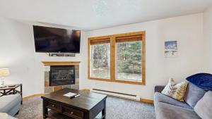 a living room with a couch and a tv and a fireplace at Payette Pines Hideaway in McCall