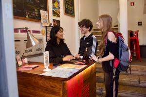 a group of three people standing around a counter at Inn Possible Lisbon Hostel in Lisbon
