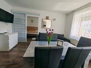 a dining room with a table with a vase of flowers on it at Eisenerzer Apartmenthaus in Eisenerz