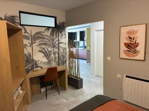 a bedroom with a desk and a room with palm trees on the wall at ALMOHADES del JERTE in Galisteo