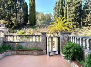 a gate to a garden with a fence and trees at la Casa de Flores in Tossa de Mar +14 photos