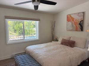 a bedroom with a bed with a ceiling fan and a window at Hikari-Okanagan Sunshine B&B in Kelowna