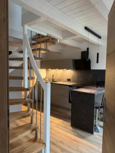 a kitchen with a staircase leading up to a loft at Fichtennest in Sundern