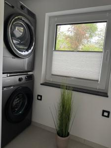a washer and dryer in a laundry room with a window at Fichtennest in Sundern