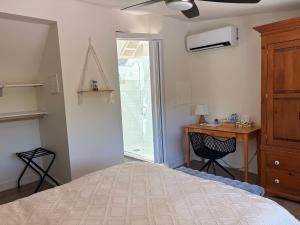 a bedroom with a bed and a desk and a window at Hikari-Okanagan Sunshine B&B in Kelowna