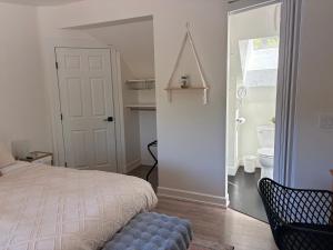 a bedroom with a bed and a bathroom with a toilet at Hikari-Okanagan Sunshine B&B in Kelowna