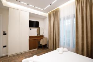 a hotel room with a bed and a desk and a television at Çifliku RSXH in Gjirokastër