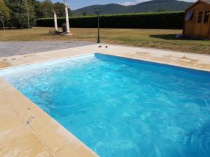 a swimming pool with blue water in a yard at La PETITE MAISON in Gourdan-Polignan