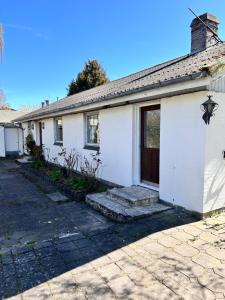 a white house with a door and a driveway at Hus in Risskov