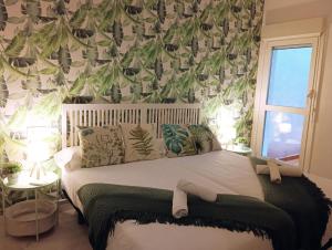 a bedroom with a bed with a green and white wallpaper at JARAUTARESORT in Pamplona