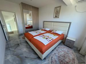 a bedroom with a large bed with an orange blanket at Villa Diel 300m vom Strand in Utjeha