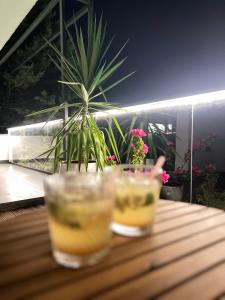 two glasses sitting on a wooden table with a plant at Mavinin ve Yeşilin dansı, Panoramik manzara, 75m2 in Marmaris