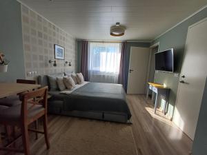 a bedroom with a bed and a couch and a television at Liisu Külalistemaja in Haapsalu