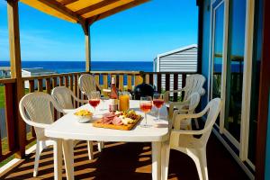 a white table with wine glasses and food on a balcony at Blueportel Prestige in Le Portel
