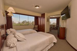 a hotel room with two beds and a large window at El Cabildo Hotel in Arequipa