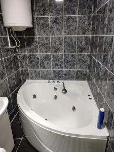 a white bath tub in a bathroom with a toilet at Tiski raj in Bečej +6 photos