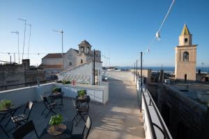 a balcony with tables and chairs and a church at Borgo Puglia in Bisceglie