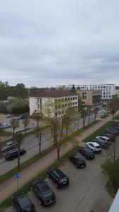 a parking lot with cars parked in front of a building at Fountain View 2 bedroom Apartment in Naujoji Akmenė