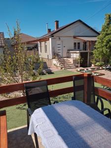 a patio with a table and two chairs and a house at Adam Apartman in Hajdúszoboszló