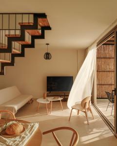 a living room with a staircase with a couch and a table at springs suites no4 in Kato Alepochori