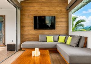 a living room with a couch and a flat screen tv at Alma de Ojochal in Ojochal