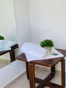a wooden table with a towel on it next to a mirror at Hotel Pousada La Vierro in Ponta Grossa