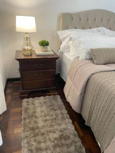 a bedroom with a bed and a table with a lamp at Hotel Pousada La Vierro in Ponta Grossa