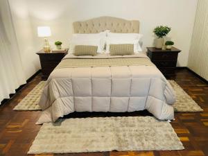 a bedroom with a large white bed with two night stands at Hotel Pousada La Vierro in Ponta Grossa