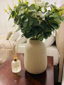 a white vase with flowers on a table at Hotel Pousada La Vierro in Ponta Grossa +41 photos