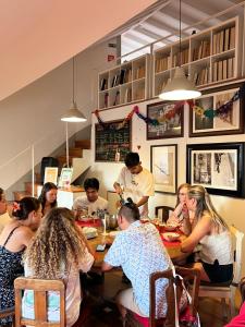 a group of people sitting around a table in a restaurant at Inn Possible Lisbon Hostel in Lisbon