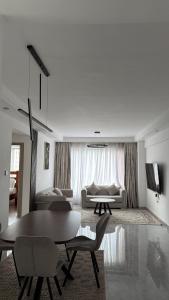 ein Wohnzimmer mit Tisch, Stühlen und Sofa in der Unterkunft Bloomstays Furnished Apartments Nairobi - Two Bedroom With Sauna Gym & Workspace in Nairobi