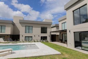 a house with a swimming pool in front of it at Almería Suites in Salta