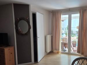 a room with a mirror and a door with a window at Le relais de la cure in Saint-Juire-Champgillon