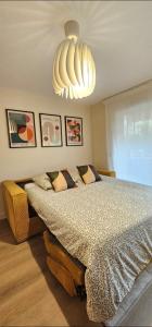 a bedroom with a large bed with a chandelier at Studio Golfe Juan bord de mer - parking & piscine in Vallauris +22 photos
