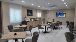 a restaurant with tables and chairs and a kitchen at Airfield Hotel & Spa in Vibo Valentia