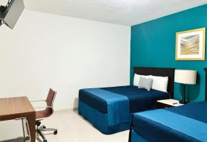 a hotel room with a bed and a desk at Hotel Palmeras Los Cabos in Cabo San Lucas