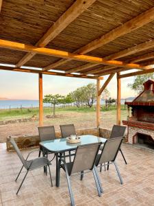a patio with a table and chairs and a fireplace at Anatèlia Beach House in Portianón