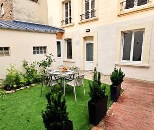 a patio with a table and chairs in a yard at D-Day Suites in Carentan