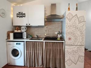a kitchen with a washing machine and a sink at El Refugio in Aracena