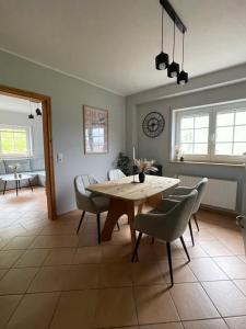 a dining room with a wooden table and chairs at Ferienwohnung Haus Liane in Reil