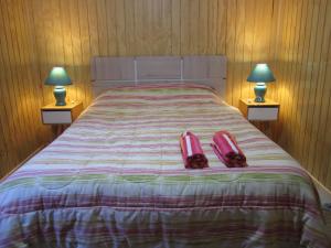 a bedroom with a bed with two shoes on it at Cabaña Pehuen in San José de Maipo