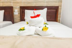 a pile of towels sitting on a bed at Tropic Garden Hotel in Banjul +30 photos