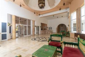 a large room with green tables and chairs at Hotel Ksar Eljem in El Jem +14 photos
