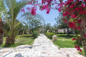 a path through the park with pink flowers at Hotel Ksar Eljem in El Jem