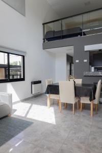 a dining room with a table and white chairs at Almería Suites in Salta